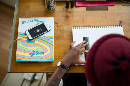 Top view of a person working on their desk, using a scale on a notebook